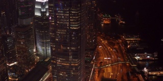 航拍场景在香港市中心的国际金融中心塔和维多利亚港周围移动，在晚上的交通，4k视频