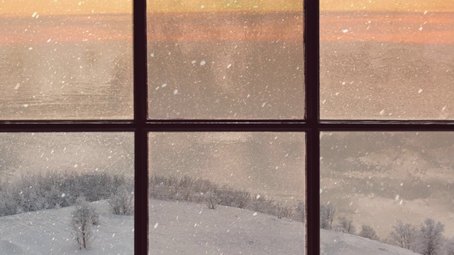 一扇木窗的剪影俯瞰着冬天的黄昏森林。美丽的冬季景观与飘落的雪