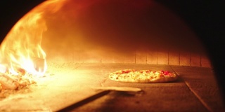 那不勒斯披萨从烧木头的烤箱里拿出来用果皮烤