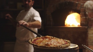 披萨师傅将新鲜出炉的带皮那不勒斯披萨放在盘子里视频素材模板下载