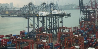 海运工业港口4K DCI与集装箱。进出口货物国际业务。大型起重机白天将集装箱卸到卡车上。