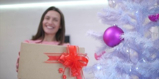 模糊的时光流逝，妈妈多么开心，在圣诞树下找到了一份送给自己的礼物，把它伸到相机前，满怀感激之情。