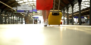 年轻的白人妇女与手提箱跑去赶火车进站之前，它离开车站没有她