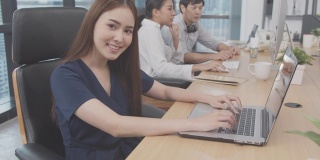 4K分辨率的年轻亚洲商务女性在室内现代办公室工作，亚洲商务办公室的生活方式