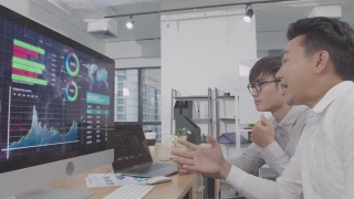 4K分辨率视频两位亚洲商人用电脑讨论和分析财务数据，投资分析财务数据概念，亚洲办公室室内商务生活视频素材模板下载