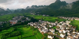 鸟瞰喀斯特山峰森林(万峰林)中的村庄和稻田，贵州，中国。