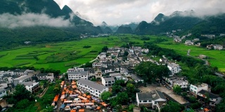 鸟瞰喀斯特山峰森林(万峰林)中的村庄和稻田，贵州，中国。
