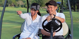 坐在高尔夫球车上的夫妇在高尔夫球场上。