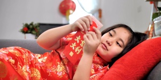 慢镜头，快乐的亚洲女孩拿着春节庆祝活动的红包