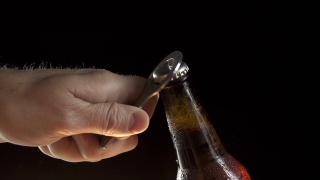 一只手打开一瓶啤酒的特写慢动作视频素材模板下载