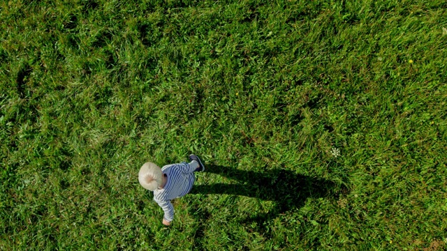 SLO MO CS金发小男孩在阳光明媚的草地上放飞气球