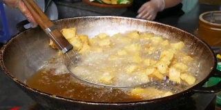 油炸豆腐在大锅或炒锅里装满油。越南街头小吃摊，垃圾食品不健康。