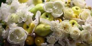 一束美丽的鲜花和水果。特写镜头。用白花组成苹果和梨。