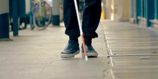 自治、失明、取向。一个盲人走在城市的人行道上