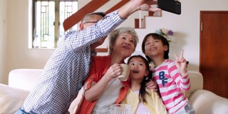 微笑的中国老人在家里与孙辈自拍