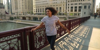 快乐的非裔美国妇女跳过芝加哥河上的一座桥
