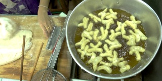 俯视图油条烹饪和手工制作，是亚洲各国著名的街头小吃。