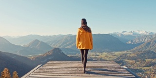MS年轻女子走到平台的边缘，俯瞰阳光明媚，风景优美的山景，失败者山，奥地利