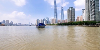 货轮在黄浦江上驶向上海陆家嘴，黄浦江沿岸的上海城市地标景观。4k慢镜头。
