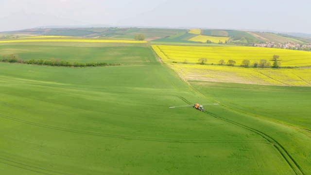一名空中的农民在一片被风力涡轮机包围的土地上喷洒杀虫剂