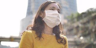 年轻的亚洲妇女咳嗽与面罩保护