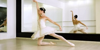年轻的芭蕾舞演员穿着白色的芭蕾舞裙，穿着她的尖头芭蕾舞鞋跳舞。4 k