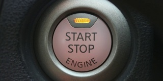 近距离的手指在一辆汽车中启动发动机按钮