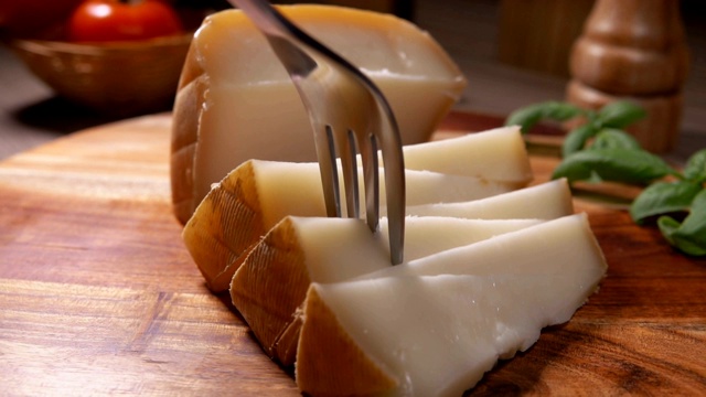 叉子拿起一块半硬的羊奶酪