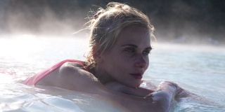美丽的女子在冰岛的温泉池中放松