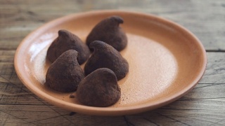 手工制作的松露巧克力糖果铺在盘子上。视频素材模板下载