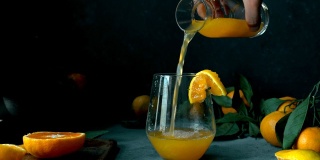 用手轻轻将陈年瓶中的橘子/橙汁倒入玻璃杯