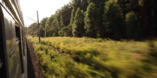 在夏日的自然和森林中，乘坐火车可以看到窗外美丽的景色。度假和旅行的概念。火车在铁轨上行驶的火车头