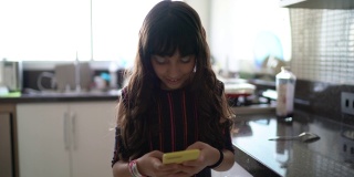 小女孩在厨房使用手机的肖像