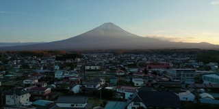 无人机鸟瞰图4k视频富士山和城市在川口湖，日本。