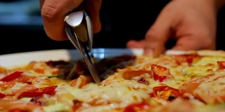 特写人物将意大利披萨切成碎片放在盘子上