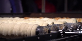 在圣诞市场上，捷克的传统街头小吃Trdelnik被烤在木头串上。捷克共和国面包店的糖衣卷，国家甜糕点Trdlo烘焙