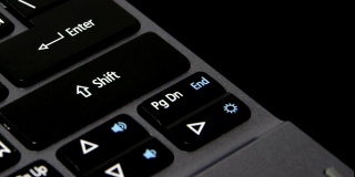 一个手指敲击笔记本键盘上的shift键