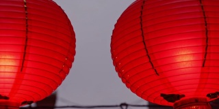 晚上走在中国传统街道上，美丽的圆形红灯笼挂着，摇摆着，这是农历新年节日的概念。