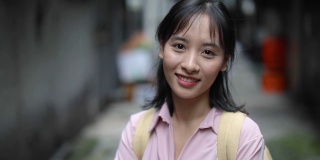 年轻的亚洲学生摆姿势和微笑