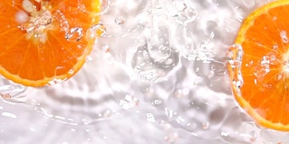 超级慢动作:橙子片落在水面上溅起水花