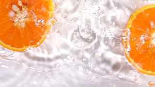 超级慢动作:橙子片落在水面上溅起水花视频素材模板下载