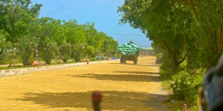 载满米袋的拖车在路上行驶