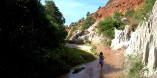 女孩沿着溪边行走在老峡谷鸟瞰图