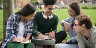 多民族群体的肖像兴奋的成年人和快乐的美国朋友闲逛在大学空间使用笔记本电脑