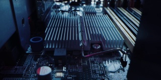 微距相机在印刷电路板上缓慢移动，显示计算机主板组件:微芯片，CPU处理器，晶体管。内部电子设备，硬件。霓虹灯的颜色