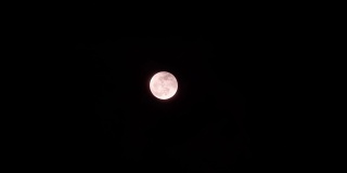明亮的满月与移动的云背景在晚上的特写，4k镜头，时间流逝，云被月光照亮。