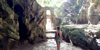 背后的女孩从山洞里走过石拱门