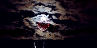 美丽的烟花表演在独立日满月和云移动