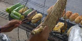 越南的街头小吃，香蕉烤米卷。特写女人的身体部分准备在街上的早餐。