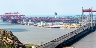 4K时间推移:鸟瞰图的自动化工业港与货船和集装箱卡车在桥上。